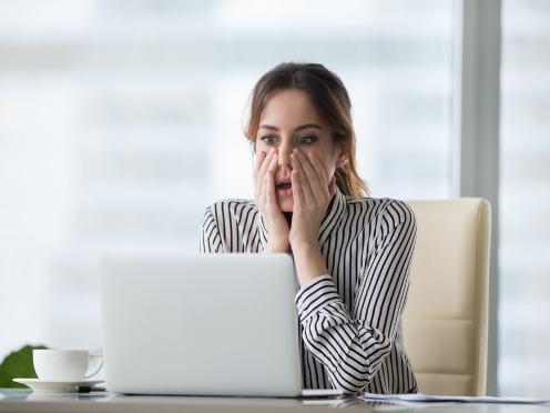shocked woman sitting at computer